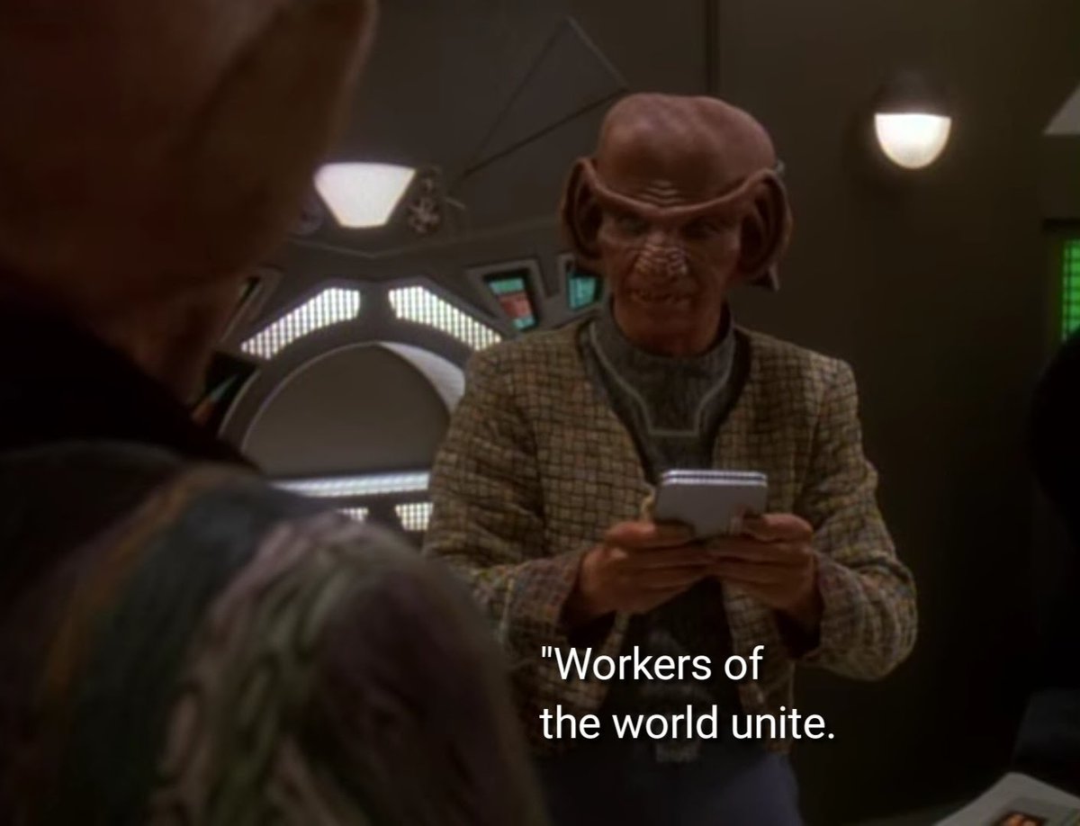 Scene from Star Trek: Deep Space Nine where Rom, the Ferengi, is telling his brother Quark "Workers of the world unite." Subtitles are visible in the image.