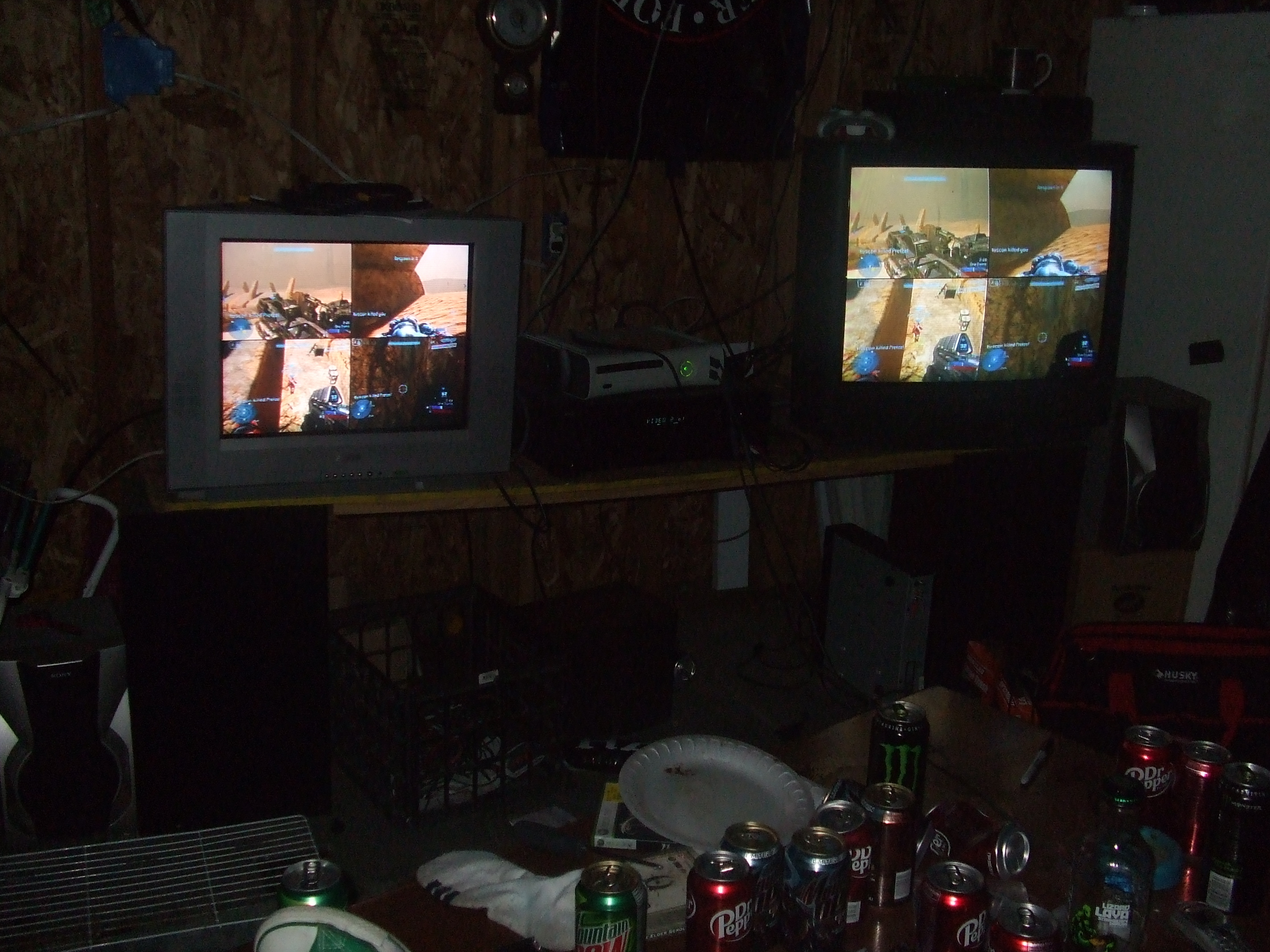 2 CRT tvs on an old table in a garage playing Halo