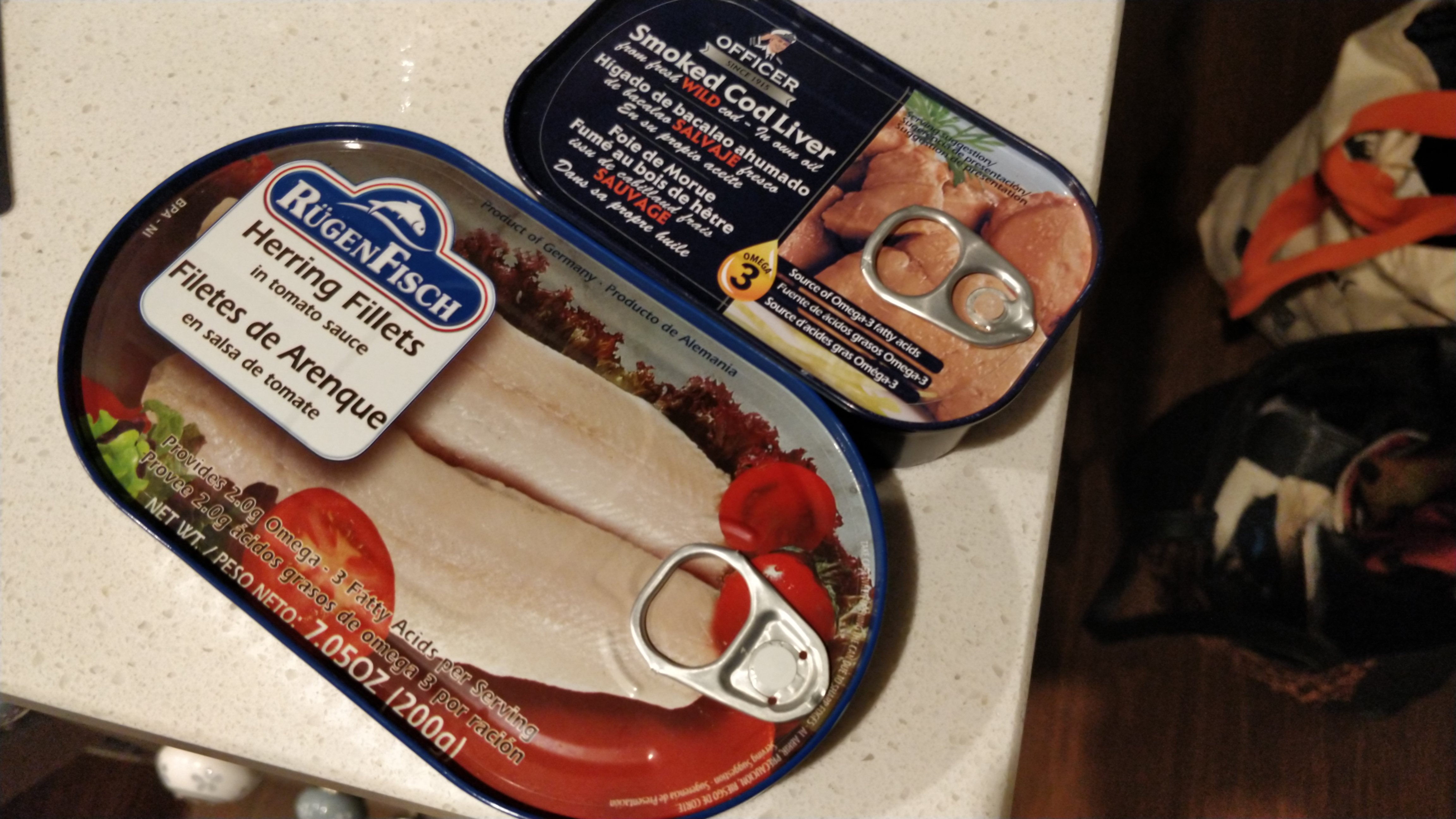 A tin of Officer brand smoked cod liver from Iceland and a tin of Rügenfisch herring in tomato sauce from Germany