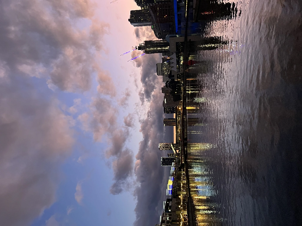 a photo of the river from queens bridge, you can see crown casino and other buildings, the sky is purple