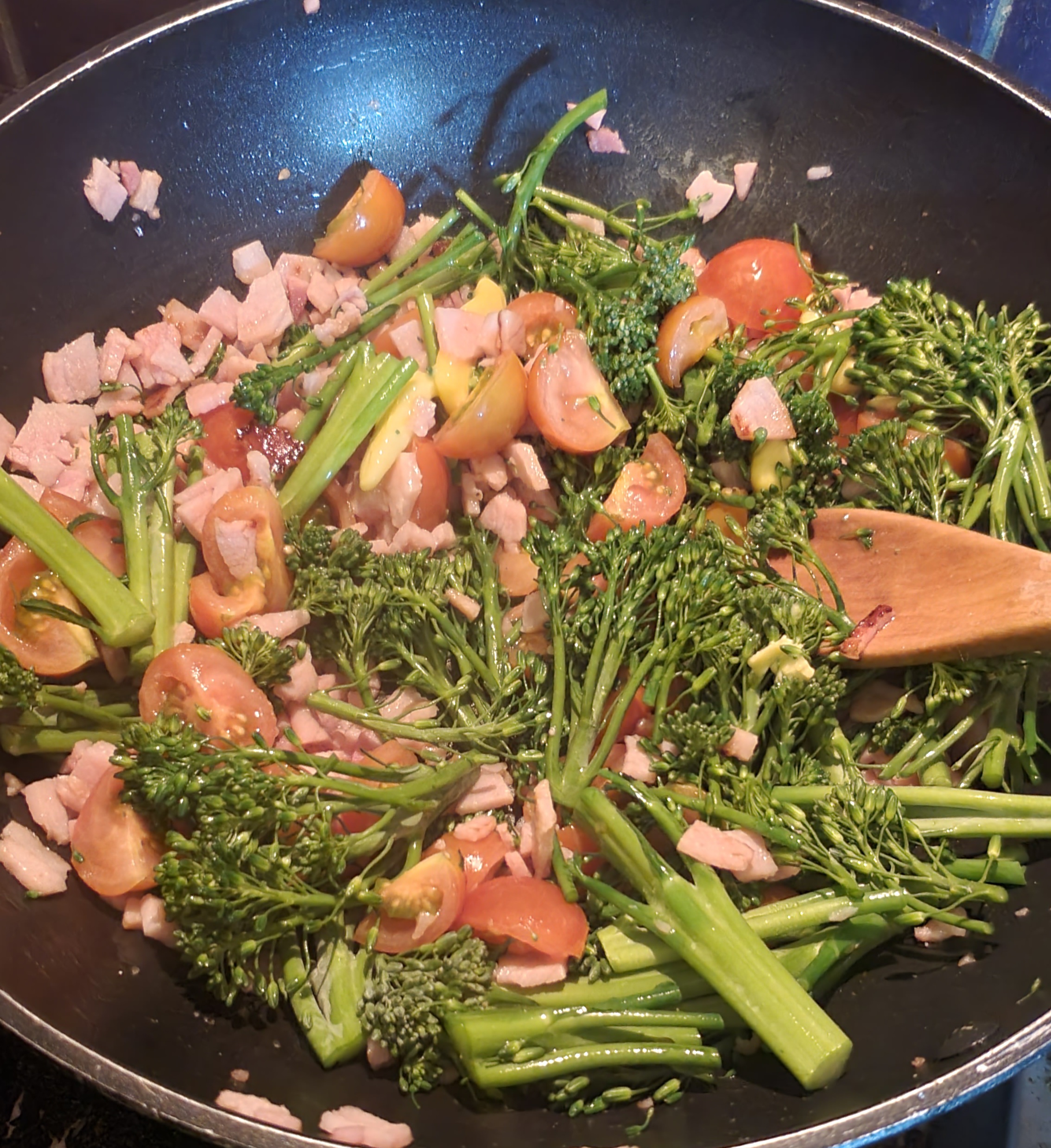 deep frypan with bacon, broccolini and tomatoes with butter