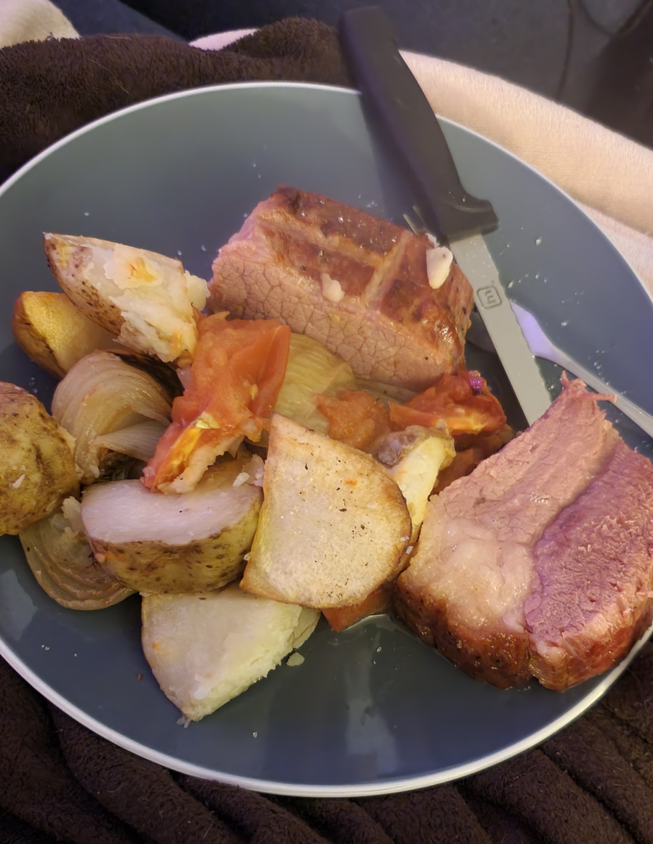 blue dinner plate with roast silverside, potatoes, onions, and tomatoes