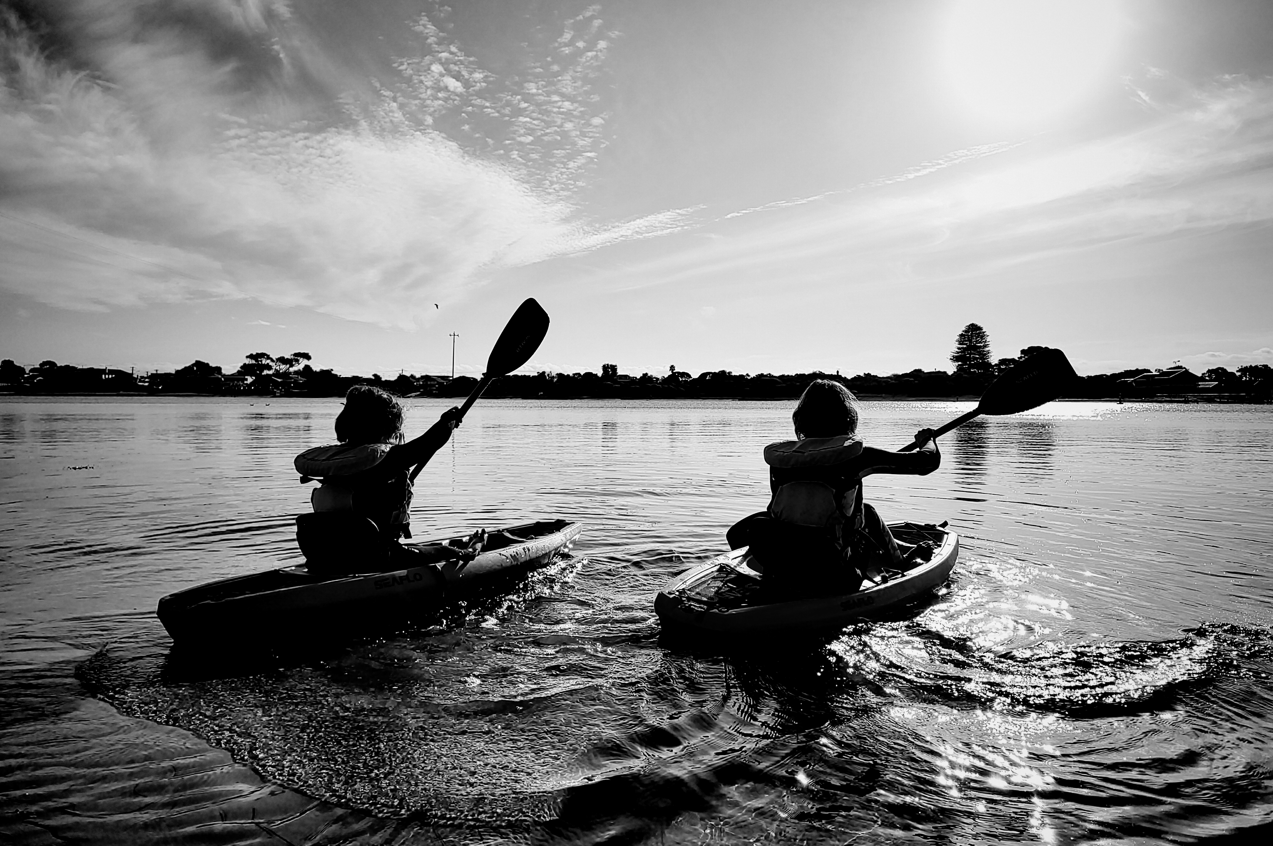 black and white image of two kids kayaking