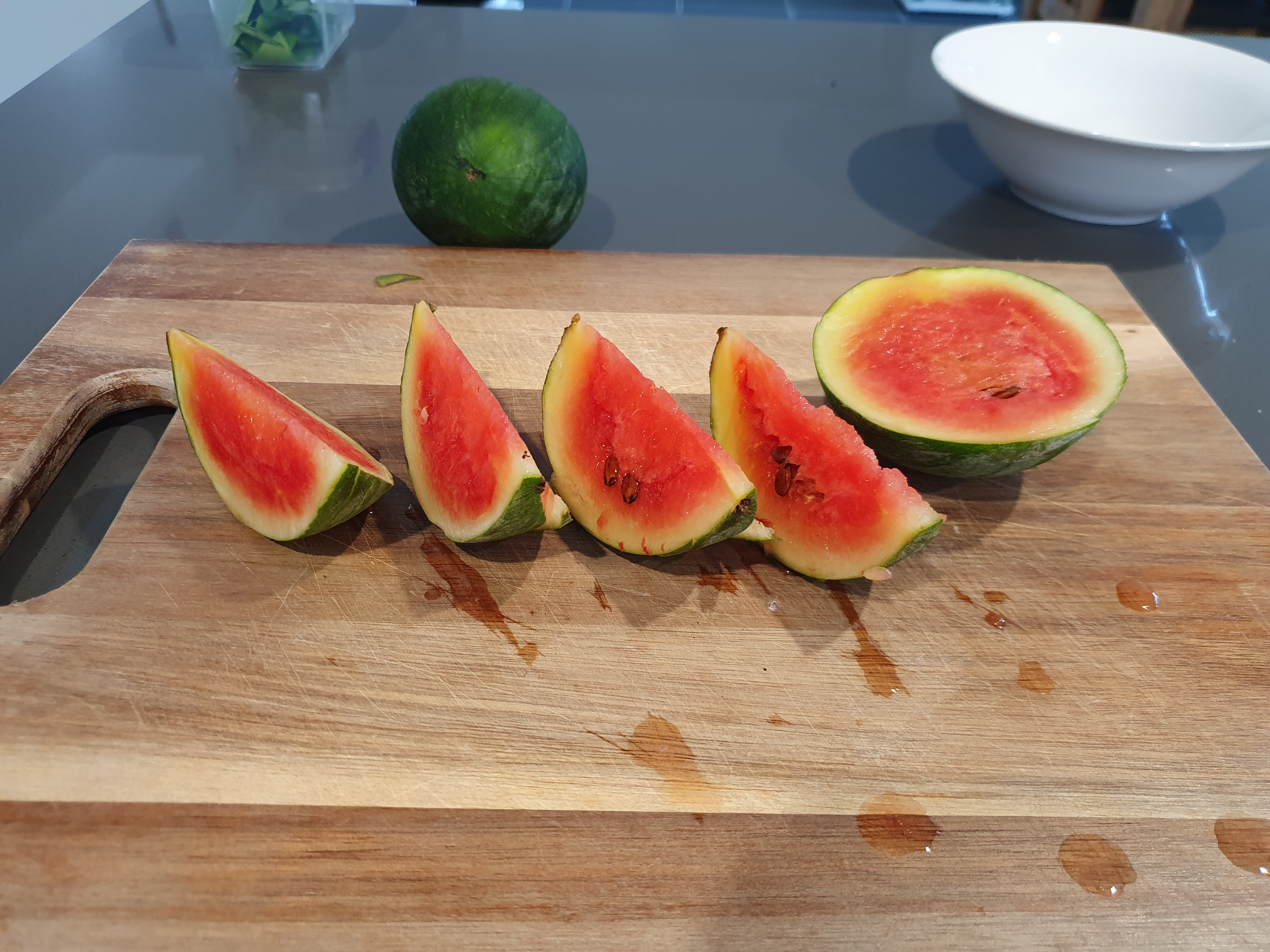 Photo of sliced up Sugar Baby Watermelon, into 4 quarters and 1 half