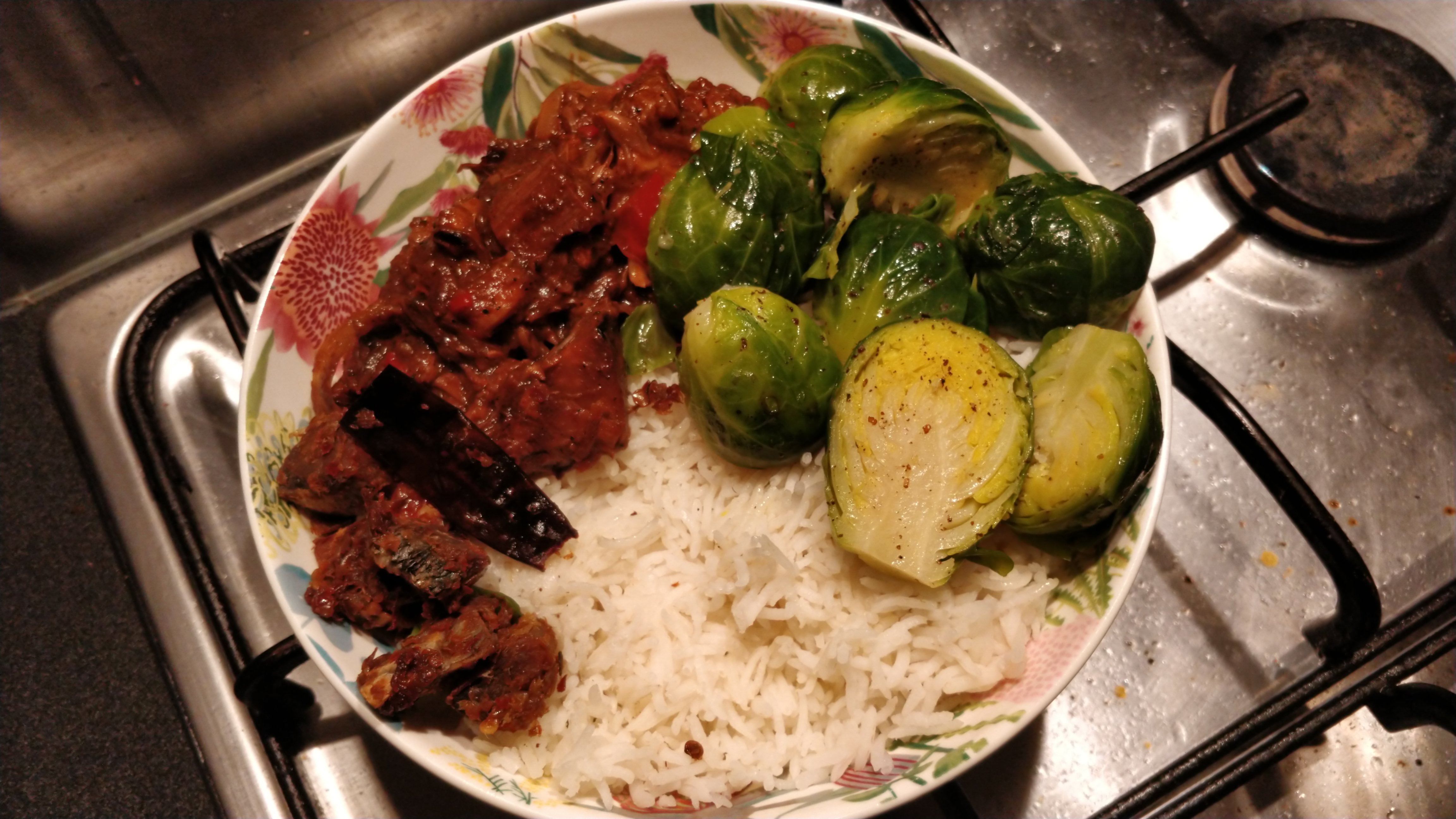 rice, jackfruit and Brussels sprouts served in a bowl with a small side of fried dry fish and dried chilli