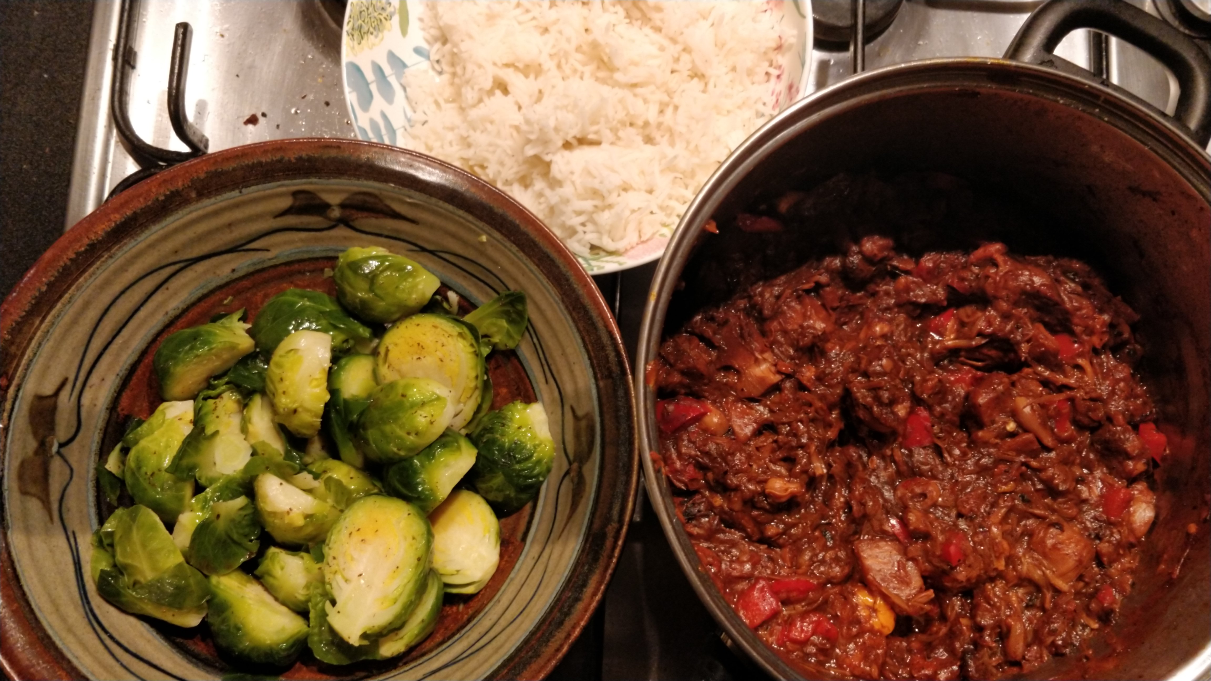 rice, jackfruit in a pot and Brussels sprouts in a bowl on a stainless steel stove