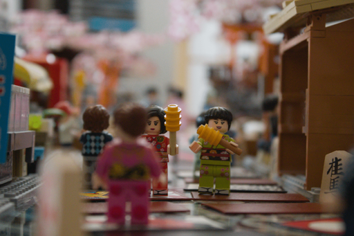 Nature morte réalisée en legos, hanafuda, pierres de go et shogi koma, représentant une rue commerçante japonaise.