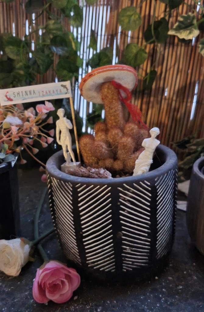 cactus in stripy pot with mini cocktail sombrero and mini roman statues