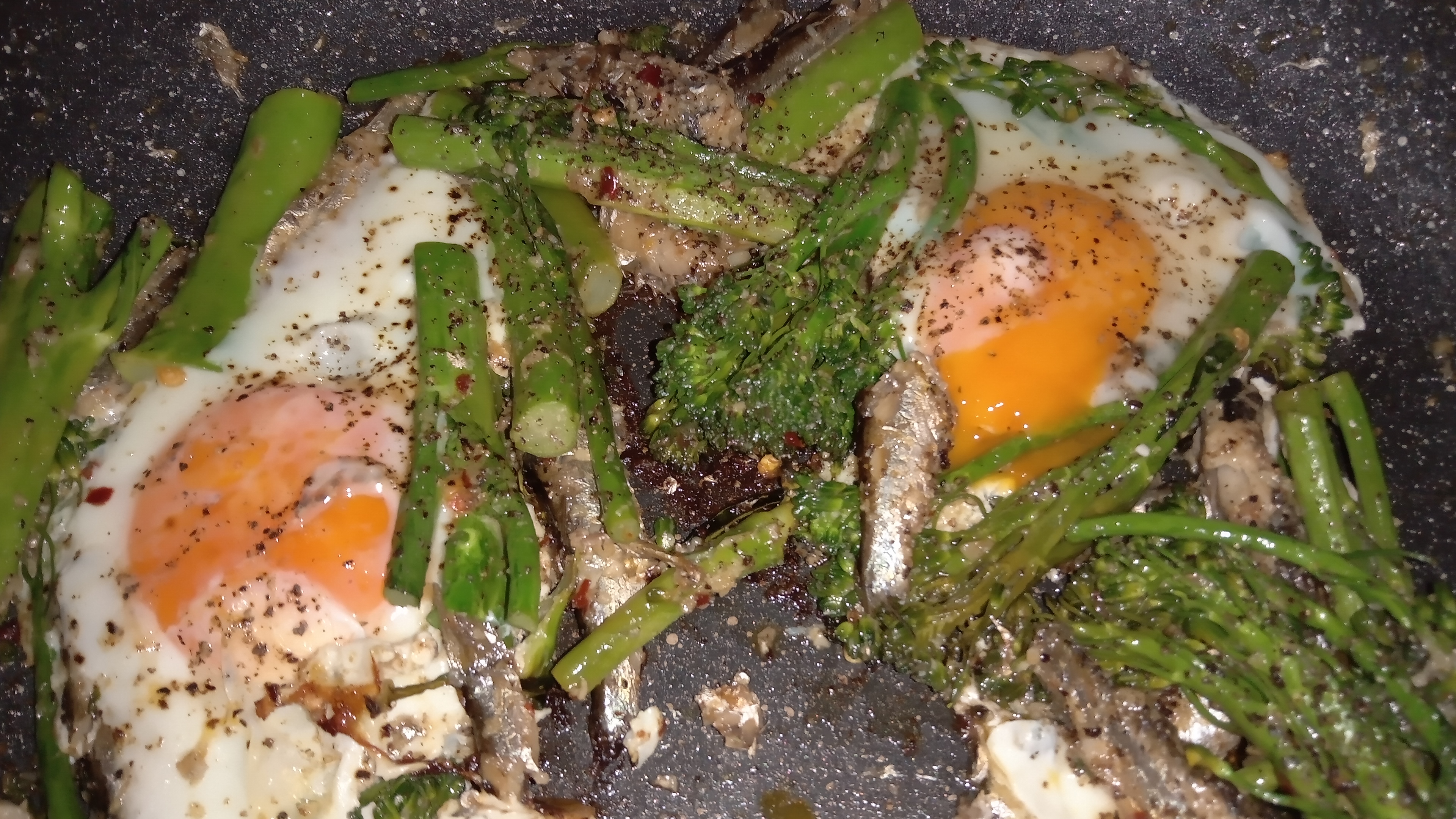 picture of frying pan with broccolini, sardines, eggs, fried in butter, garlic and chilli